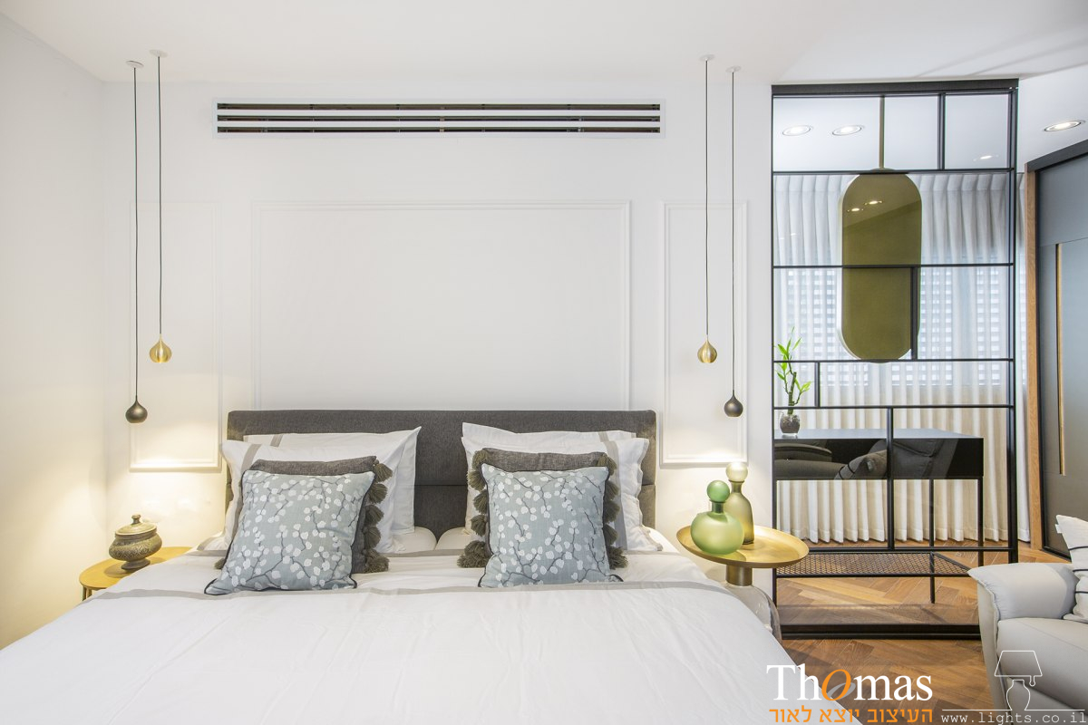 זוג מנורות תלויות משני צידי המיטה בחדר השינה משמשים כתאורת קריאה ליד המיטה