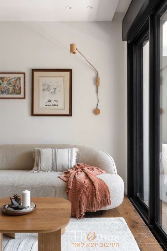 מנורת קיר מתכווננת במראה עץ מעל ספה בסלון